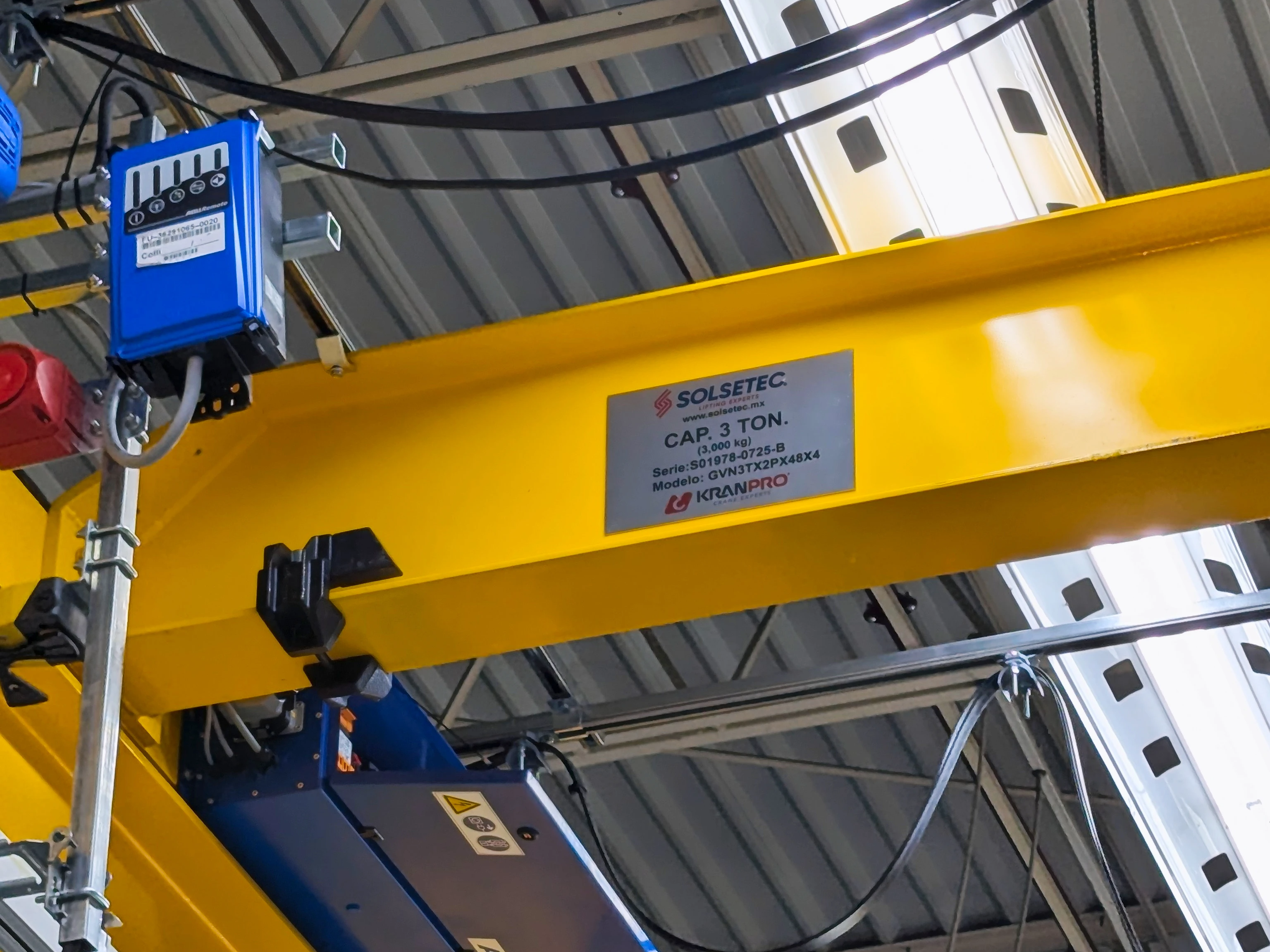 Primer plano del cabezal y ruedas de una grúa viajera industrial.